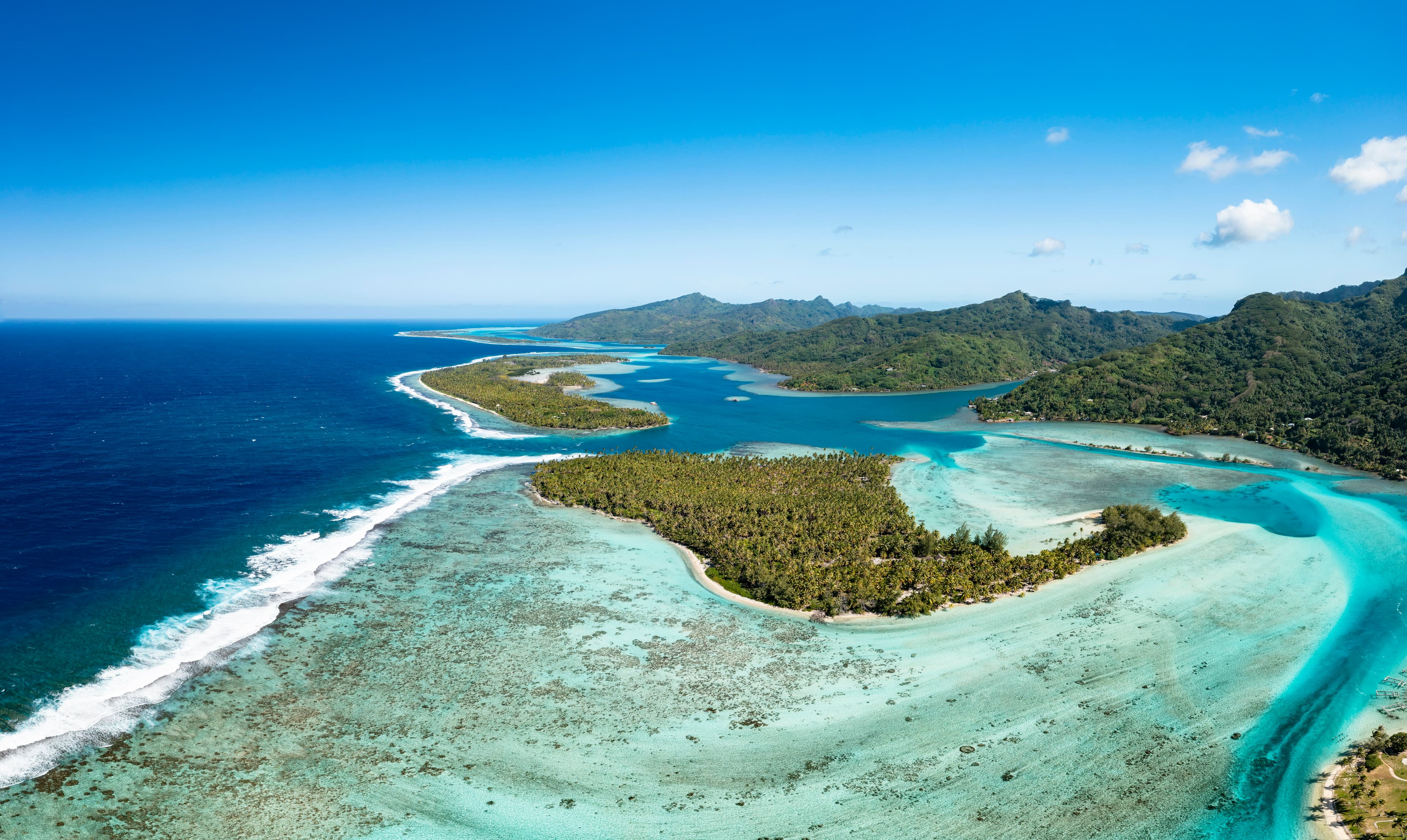 Aerial view of Southeast Asian island with turquoise lagoon and dense tropical jungle