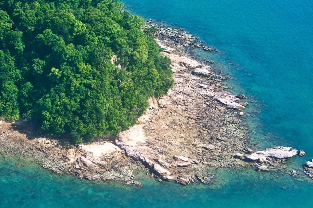 Aerial view of Langkawi's archipelago — parachute canopy descending toward Tanjung Rhu Beach